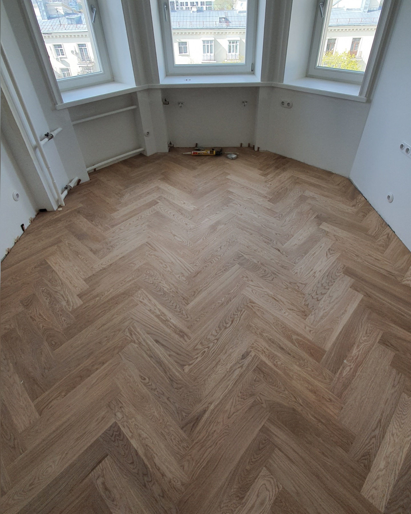 Finished oak herringbone parquet in a bright apartment room