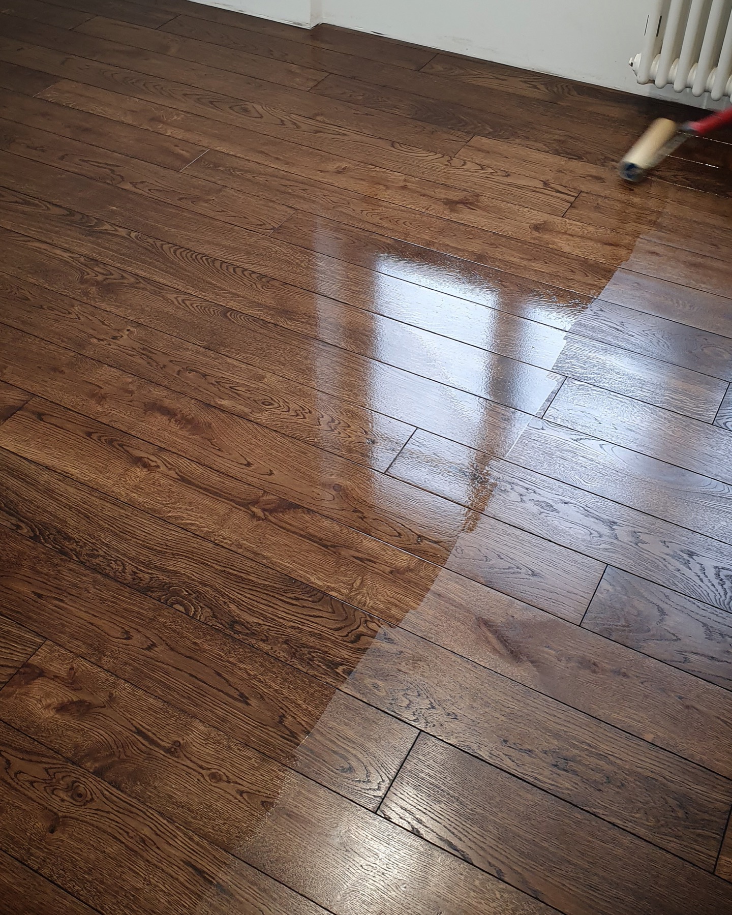 Half of the solid oak floor finished to show the color contrast