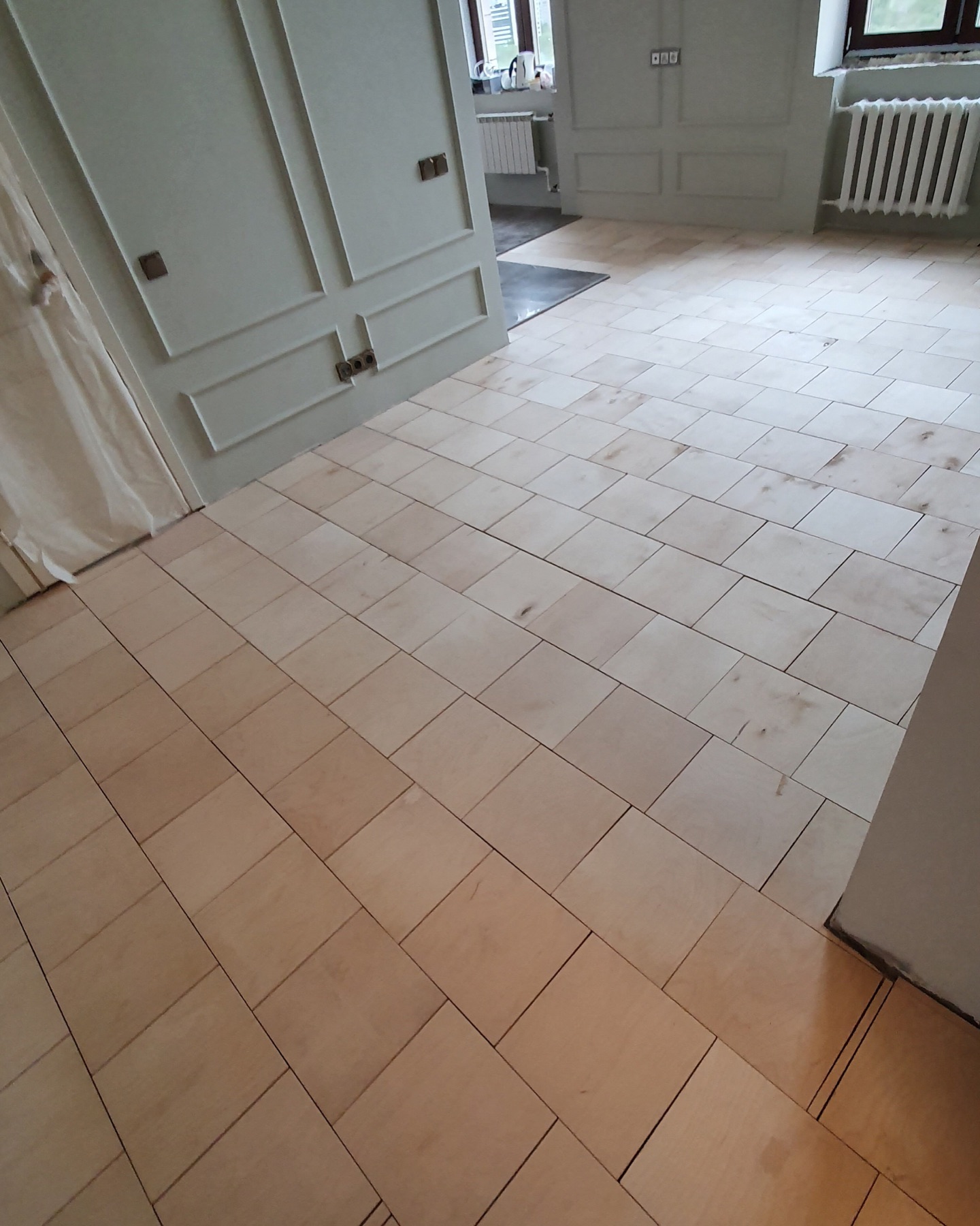 Plywood installed across the kitchen and dining area before sanding