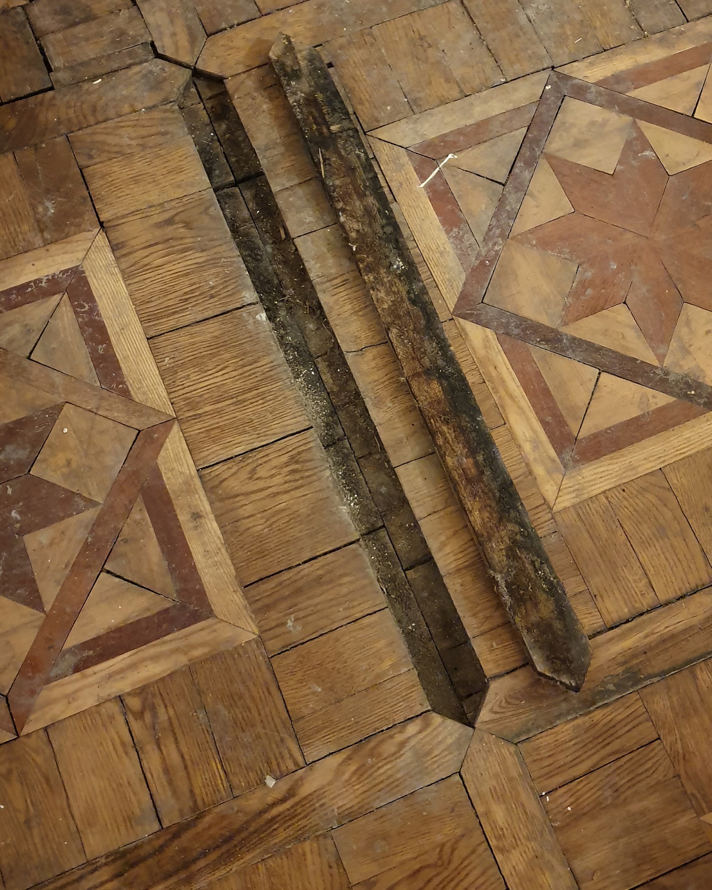 Damaged section of mosaic parquet with missing elements prepared for restoration