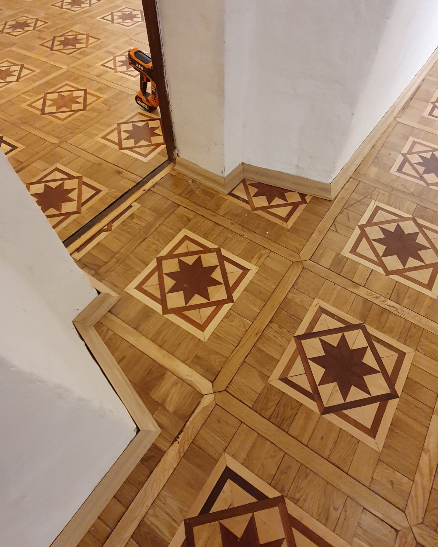 Oak skirting installed along the perimeter of the restored parquet