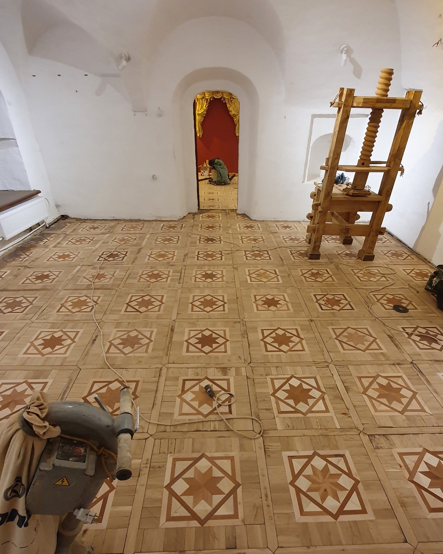 Mosaic parquet after restoration and sanding across the historical room