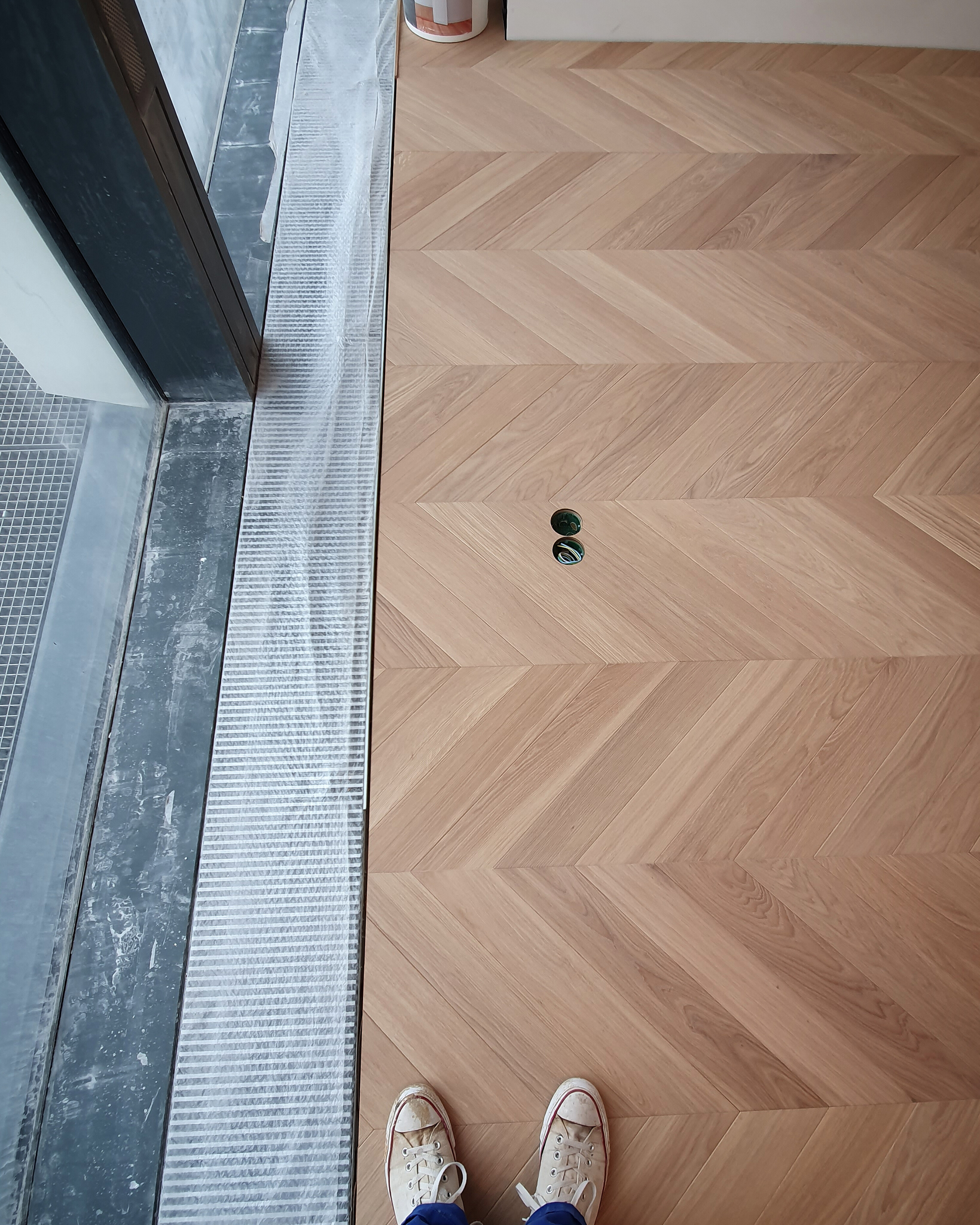 Finished parquet detail near an in-floor convector and floor socket openings