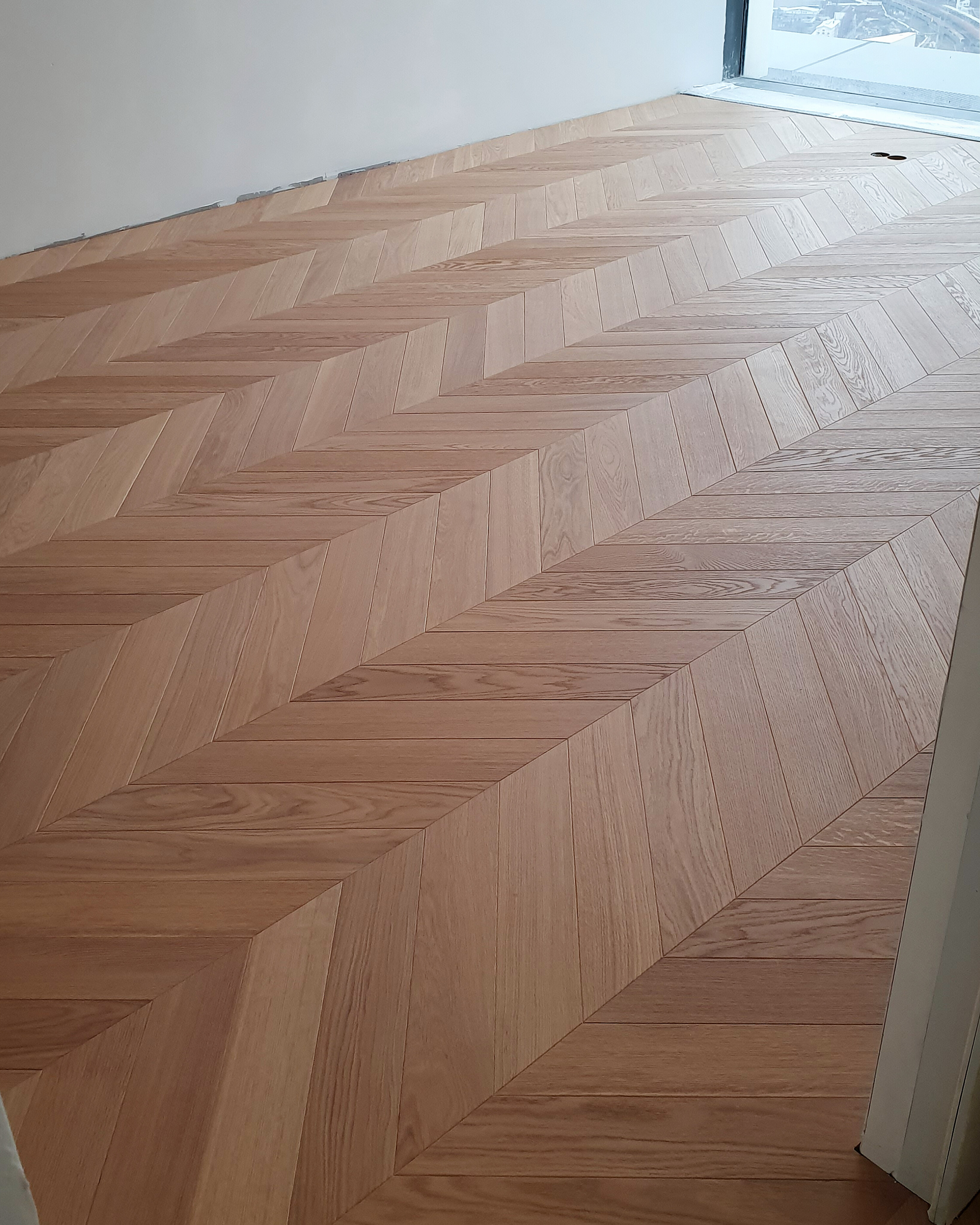 Finished French chevron parquet pattern in the completed apartment room