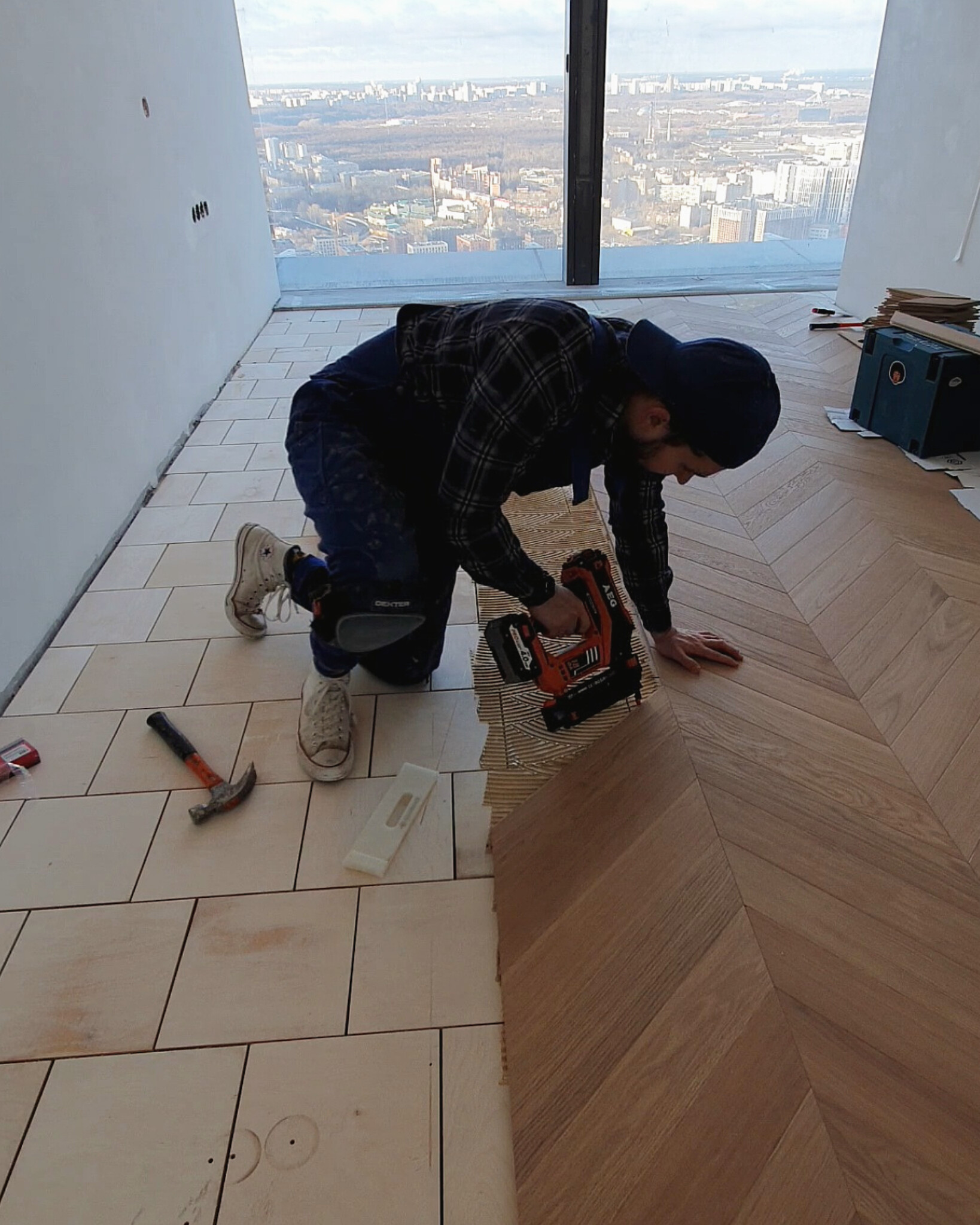 Installing French chevron parquet in a high-rise apartment with panoramic windows