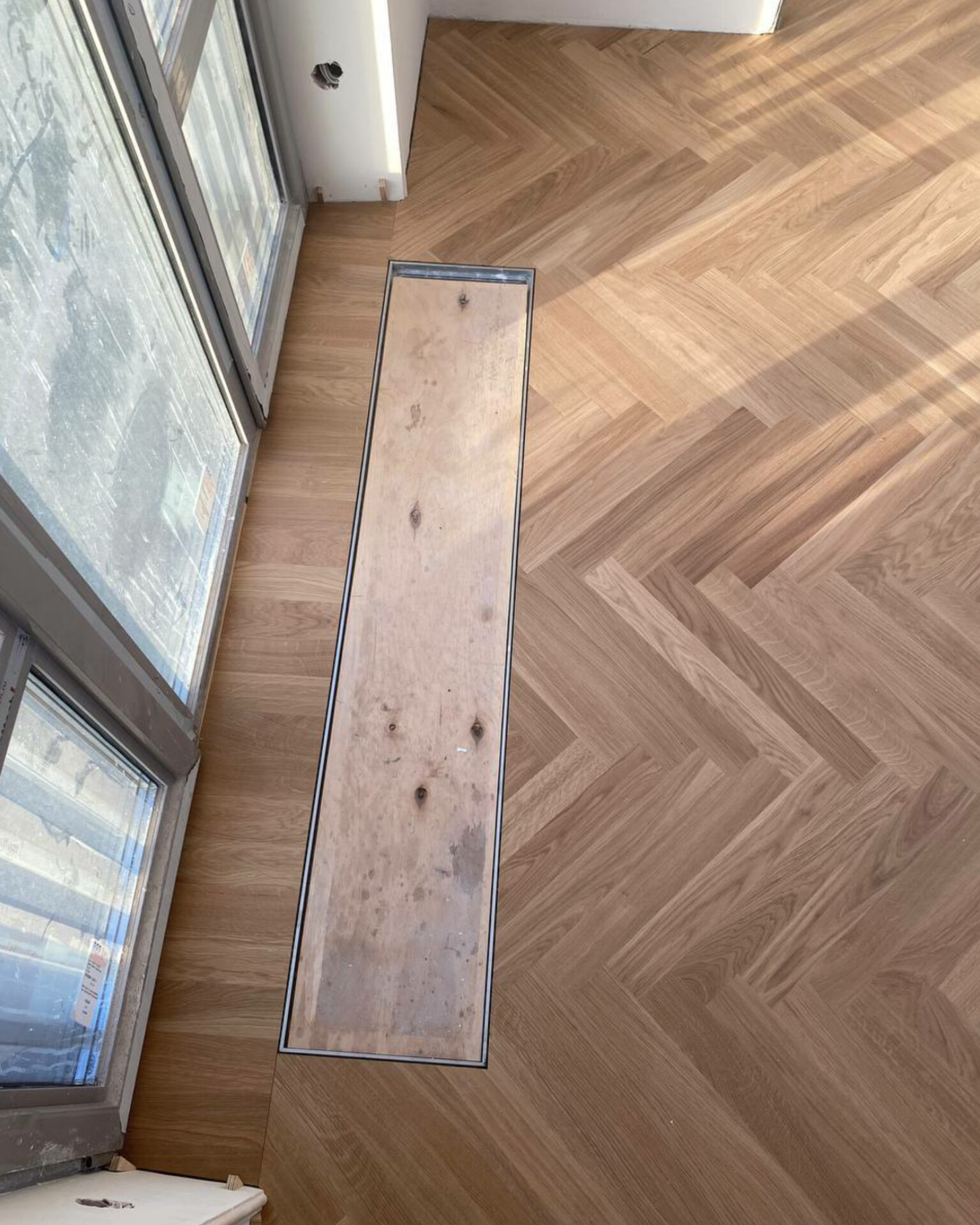 Parquet board carefully fitted around an in-floor convector opening