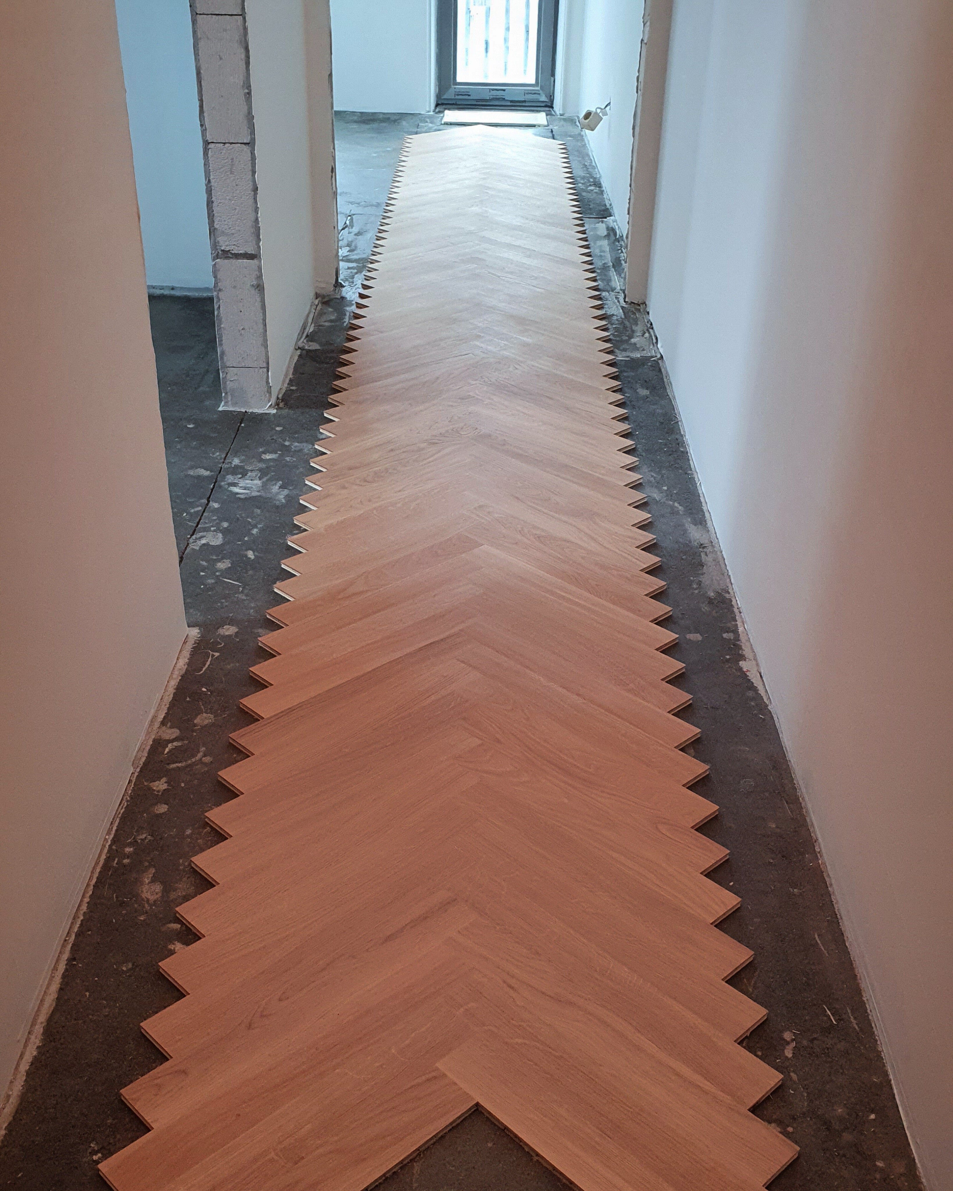English herringbone layout planned through a long apartment hallway