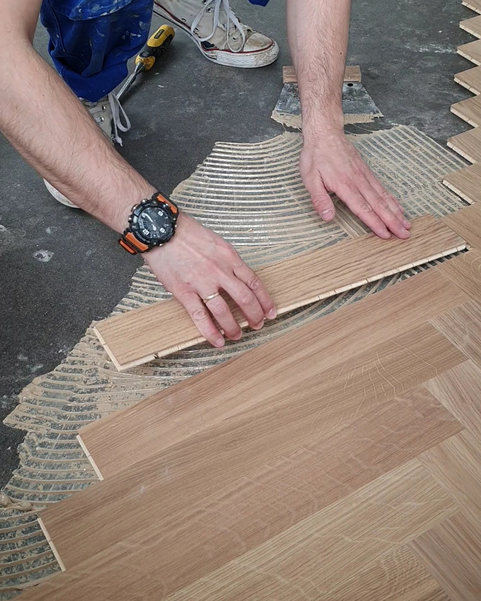 Installing Kahrs parquet board on adhesive during English herringbone fitting