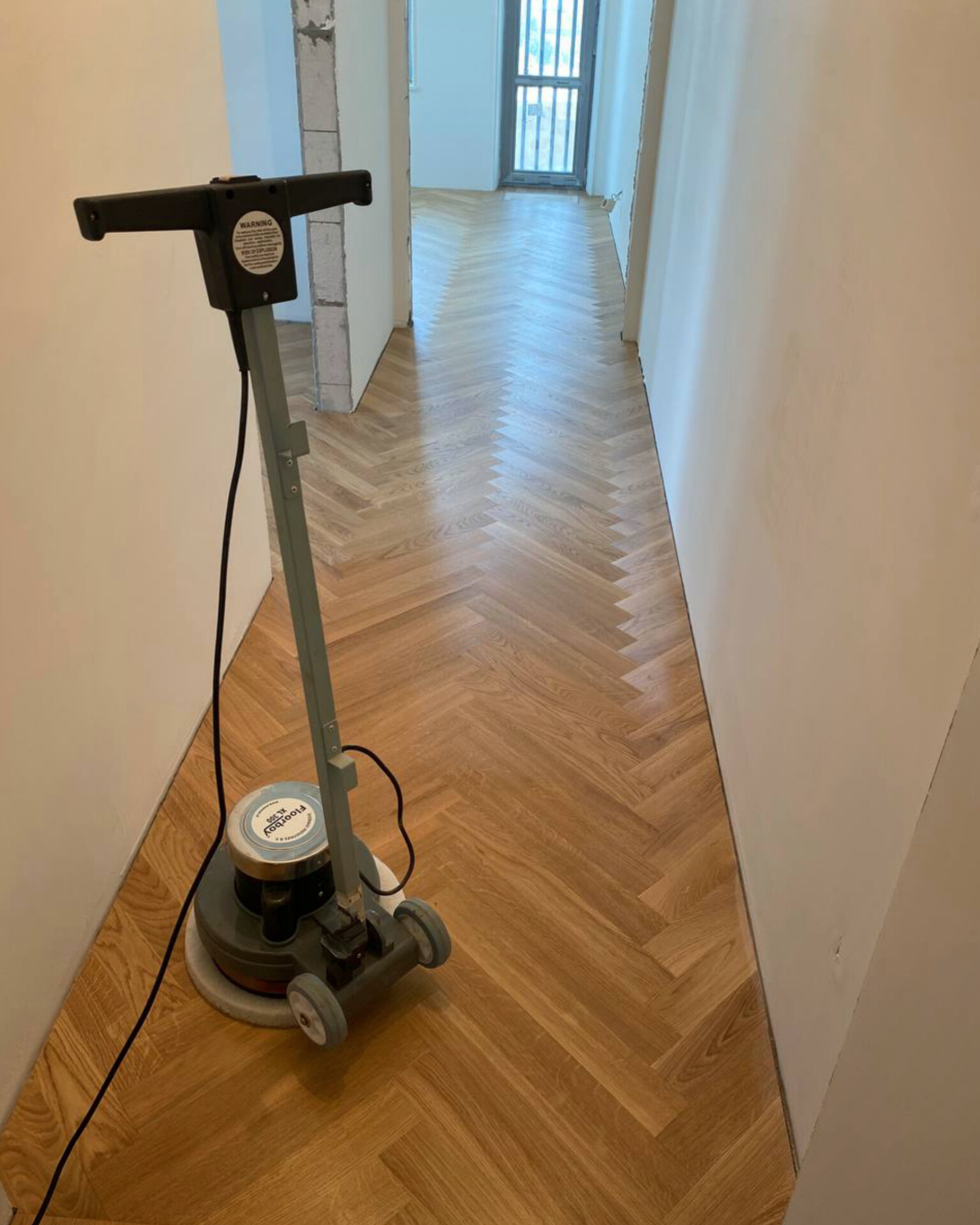 Protective oil being applied to the finished English herringbone parquet