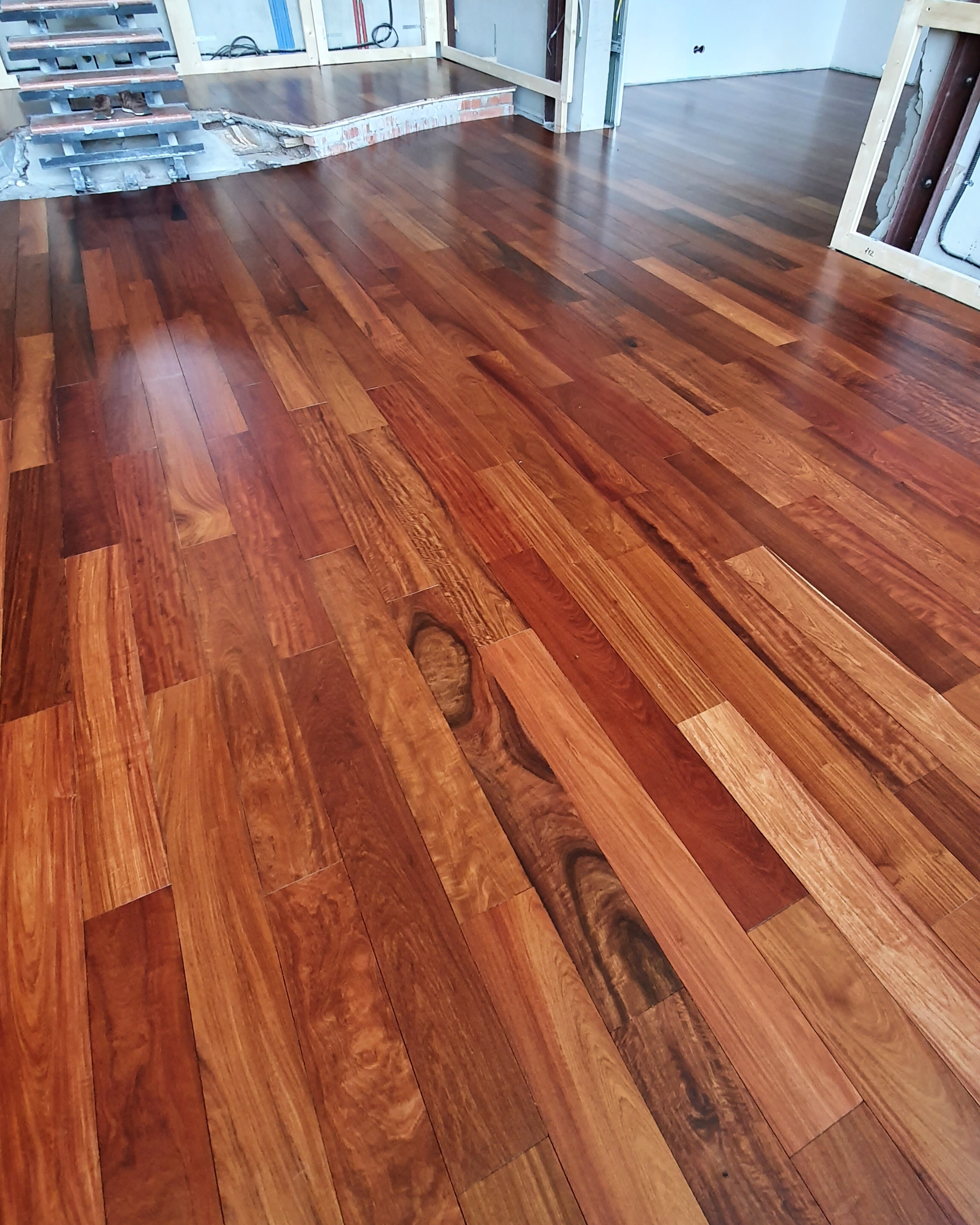 Final lacquered padauk floor showing rich grain and deep exotic color