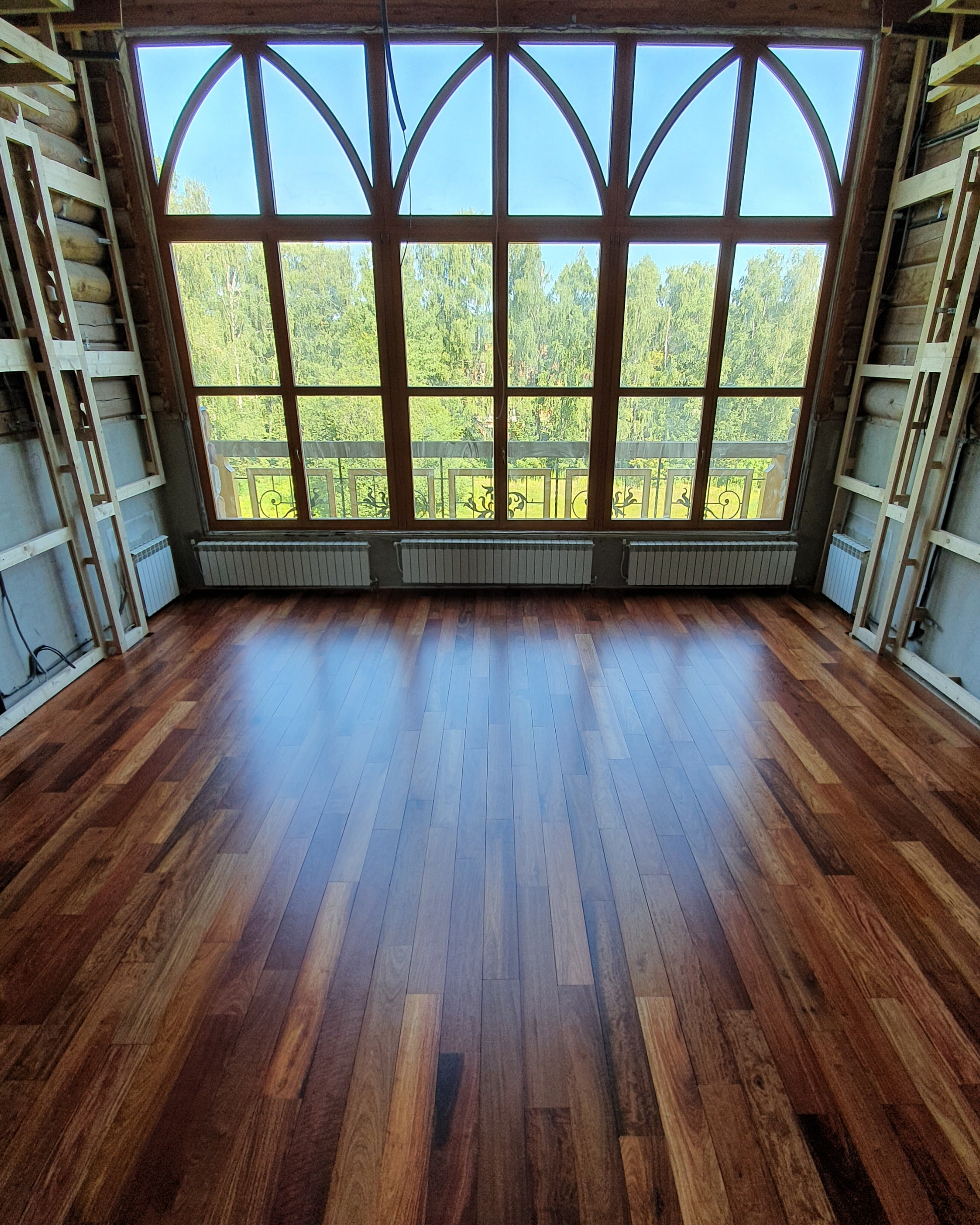 Restored exotic padauk floor in a large private house with panoramic windows