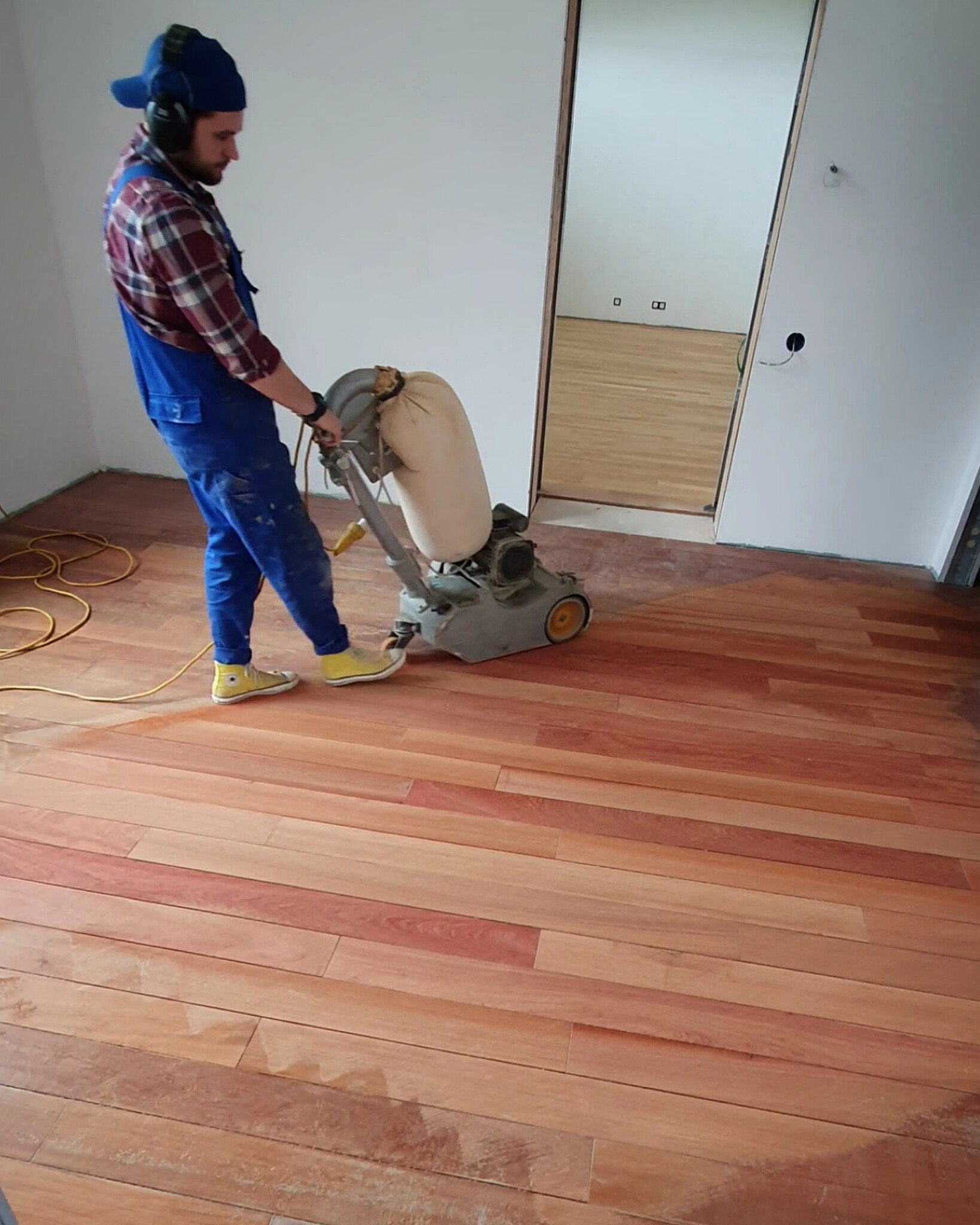 Sanding and repair work in progress on an exotic padauk floor