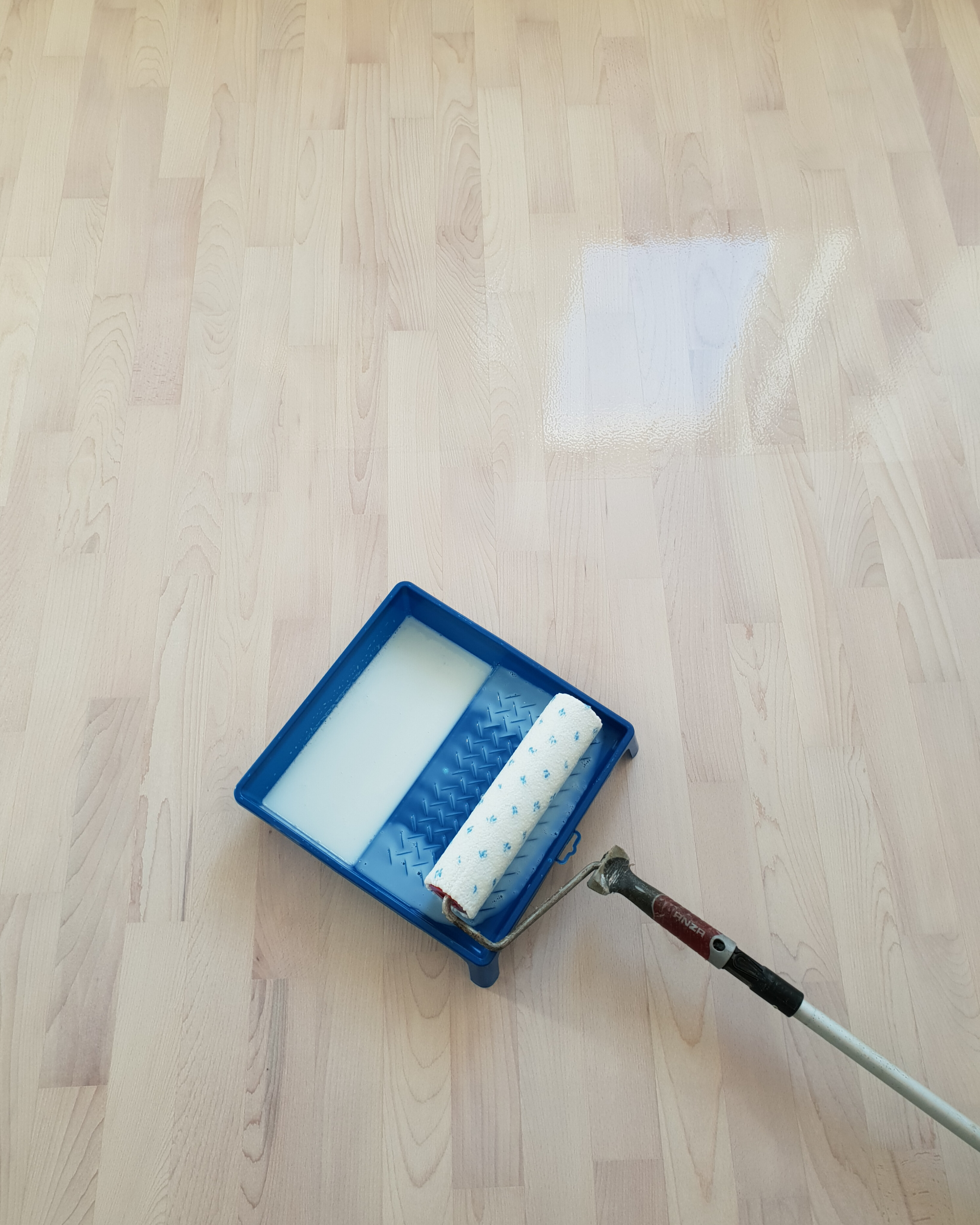 Applying lacquer over the white-toned beech parquet floor