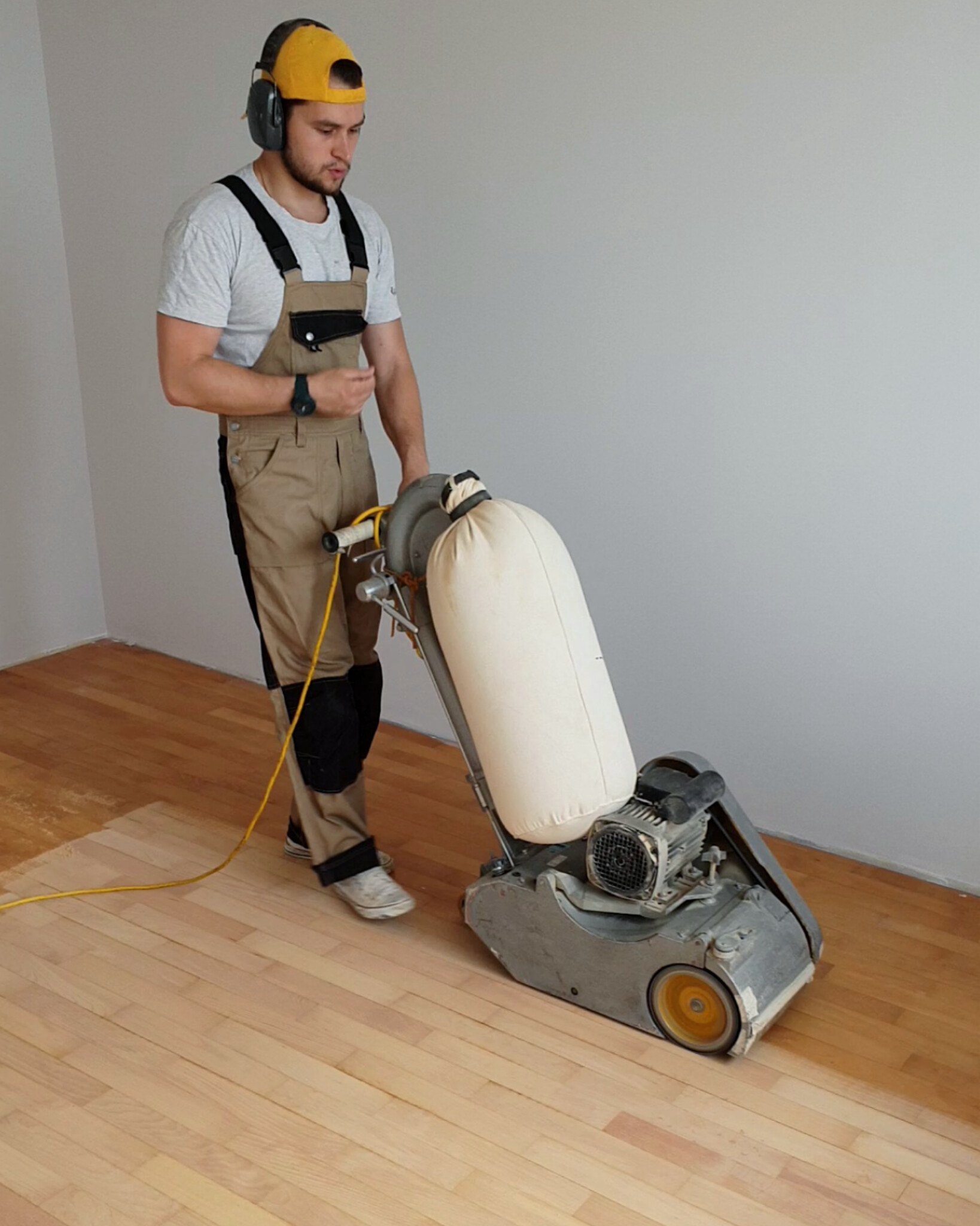 Sanding the beech parquet floor with a belt sanding machine