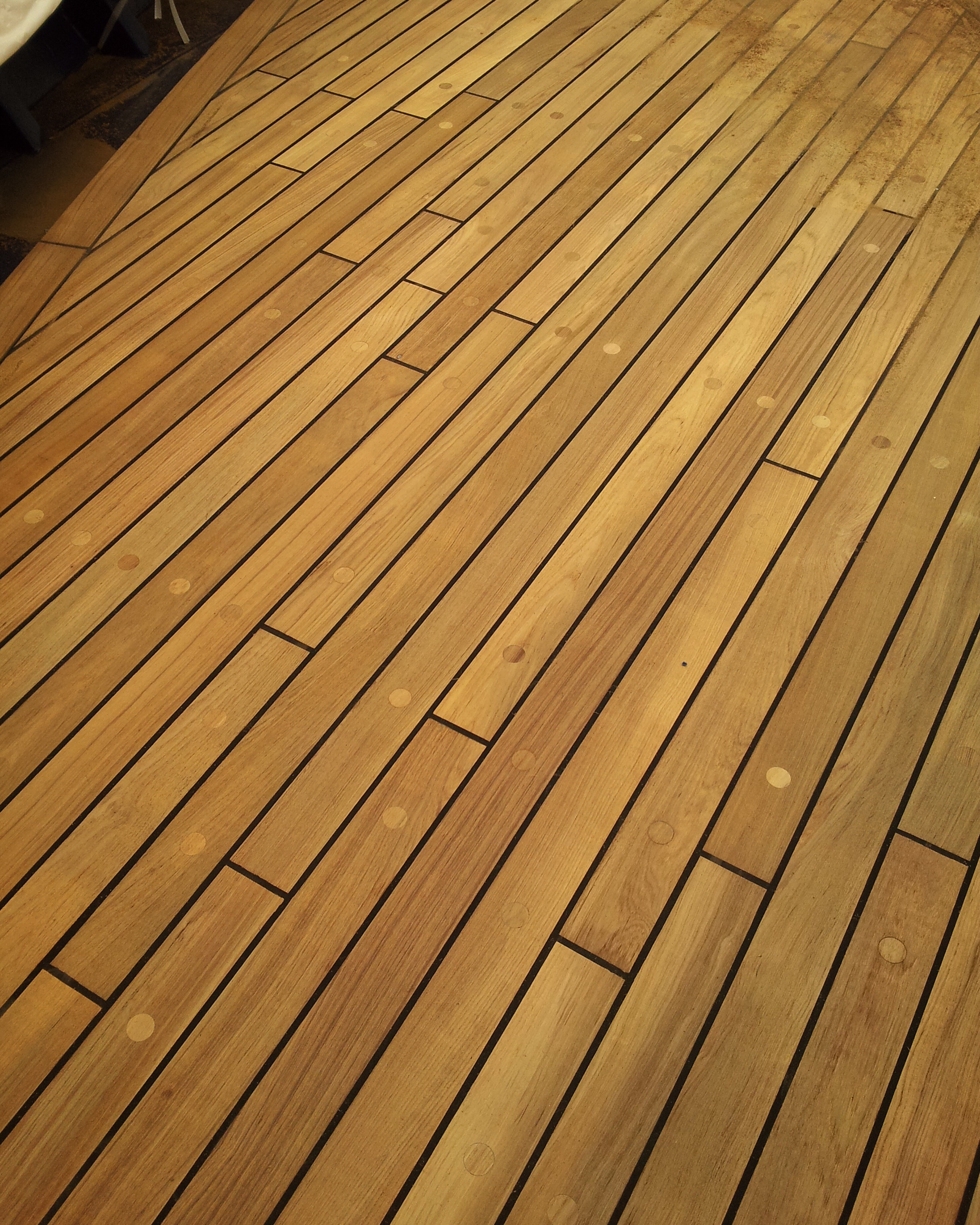 Close-up of restored teak ship deck planks and dark Sikaflex seams